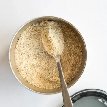 Vital Roots Talbina Original Powder – Natural Barley Porridge Mix Close-up overhead view of Vital Roots Talbina Original finely ground porridge powder in a bowl with a metal spoon.